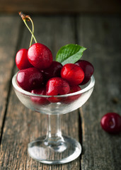 Ripe cherries in ice-cream bowl with leaf