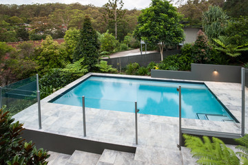 Modern swimming pool with a glass fence on the floor