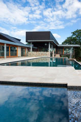 Modern swimming poolside with a luxury house or hotel