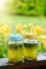 Summer drink lemonade with lemon and mint in mason jar outdoor