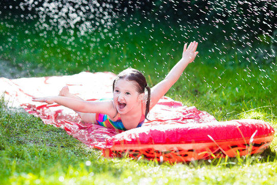 Child Playing With Garden Water Slide