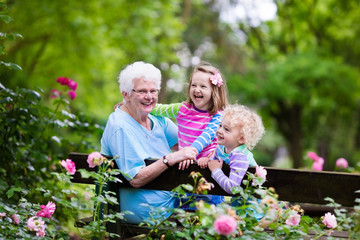 Grandmother and kids sitting in rose garden