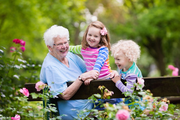 Grandmother and kids sitting in rose garden