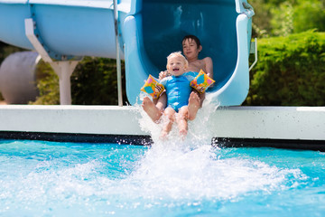 Kids on a water slide in swimming pool