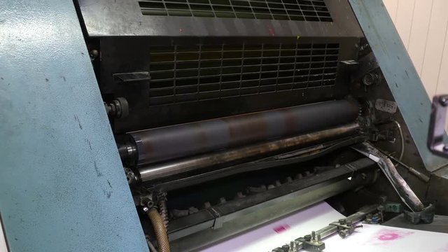Printing roller helps to deliever sheets of paper into printing press. Printing industry, old mechanism. Seamless loop. 4K Ultra HD.