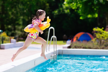 Little girl jumping into swimming pool