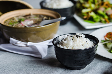 Bowl of rice with another asiatic foods at background