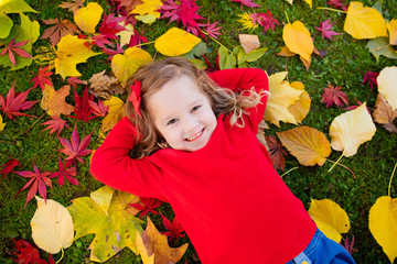 Little girl playing in autumn park