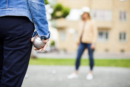 Senior women playing boule at field against building