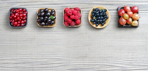 Set of different berries on wooden background. Copy space for your text. Top view, high resolution product.