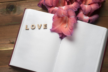 The word love a lot of hearts on a background of book on a wooden table. Back to school copy space. Education background.