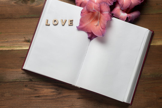 The word love a lot of hearts on a background of book on a wooden table. Back to school copy space. Education background.