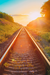 Fototapeta na wymiar Railway Going Straight Ahead Through Summer Hilly Meadow To Suns