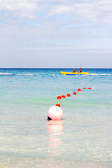 Obraz premium Tourists float on a banana shaped inflatable boat. Active sports leisure. Varadero sandy beach at sunny day. Cuba.