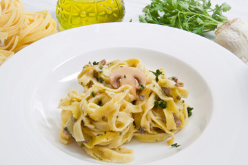 dish with tagliatelle and mushrooms and fresh ingredients