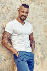 Fototapeta premium Outdoor fashion portrait of young handsome man in white t-shirt
