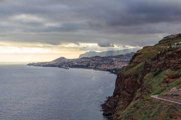 Funchal coastline under the typical cloudy sky before sunset.