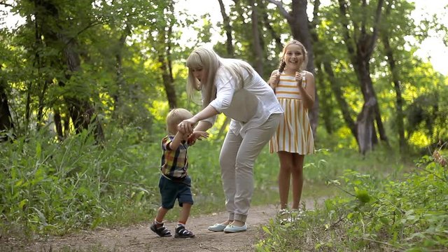 Mom plays with her daughter and son in the park