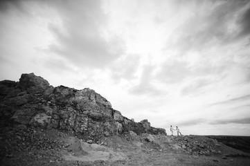 Pregnant woman and man photo shoot in a stone quarry