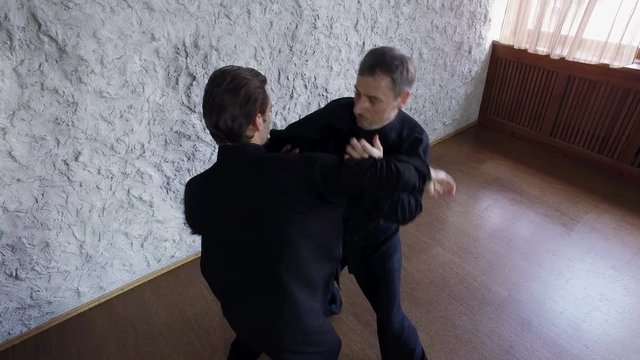Training in the hall. Two men practicing the elements of tai chi. 4K