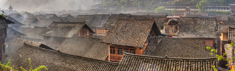 Morning fog over tiled roofs of peasant houses in chinese village