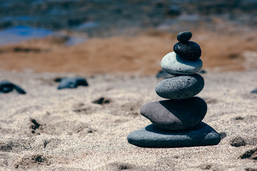 Fototapeta na wymiar Stones balance on vintage beach, inspirational summer landscape.