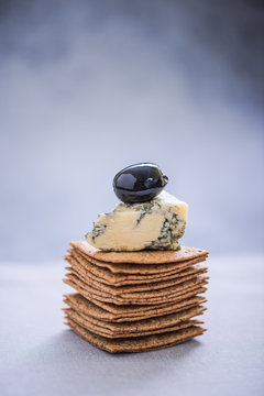 pile of crackers with brie and olive