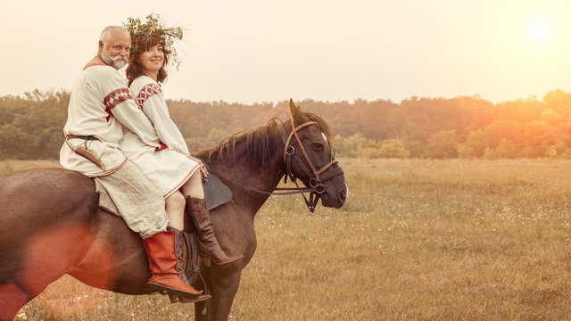 Mature Man And Woman Are Riding A Horse On The Rural Summer Back