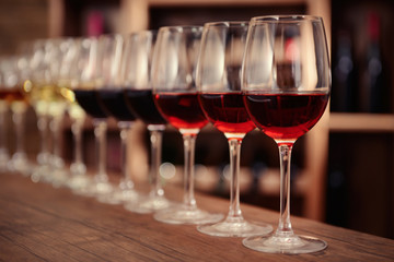 Many glasses of different wine in a row on bar counter