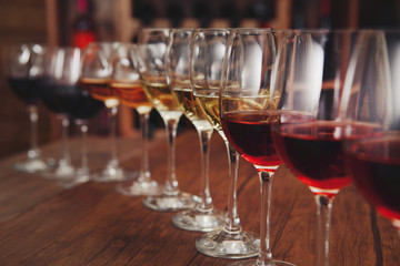 Many glasses of different wine in a row on bar counter