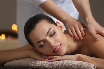 Fototapeta na wymiar Young beautiful woman having massage in spa salon