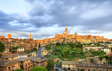 Fototapeta na wymiar Siena sunset panoramic skyline. Mangia tower and cathedral duomo