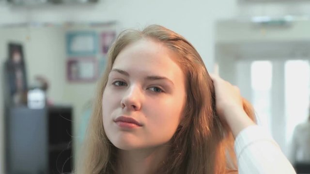 The girl without make up smiling at a beauty salon