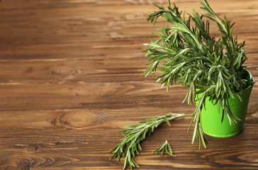 Fresh rosemary in bucket on wooden table