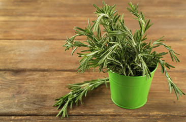 Fresh rosemary in bucket on wooden table
