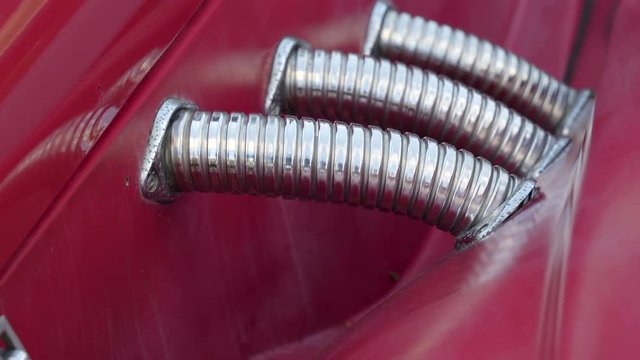 The red vintage russian car and the silver part from the side of the car being parked