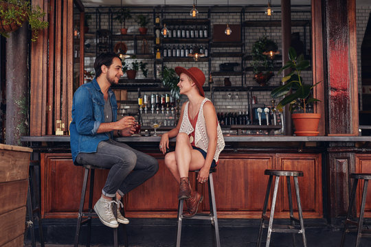 Young couple sitting at cafe counter - Powered by Adobe