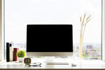 Creative workplace with blank monitor
