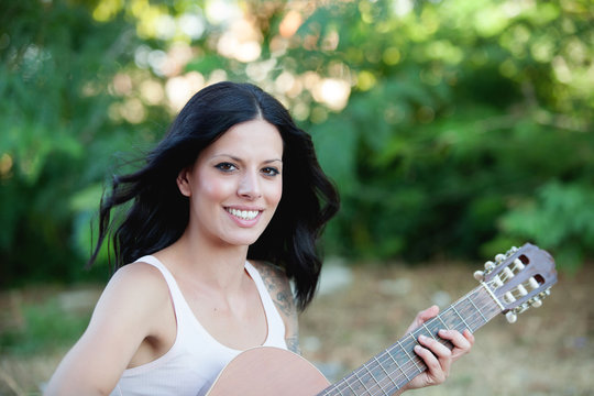 Brunette pretty woman with a guitar