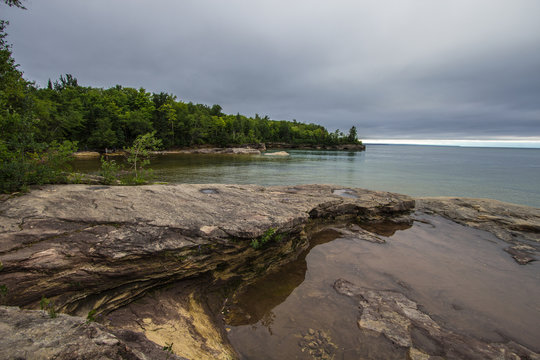 Sandstone Beach On Lake Superior. Sandstone peninsula juts into the vast blue waters of Lake Superior in Michigan.