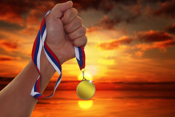 Fototapeta na wymiar The sportsman holding a gold medal