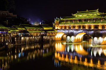 Hong Bridge at night in Fenghuang Ancient town, Hunan province, China. This ancient town was added to the UNESCO World Heritage Tentative List in the Cultural category.