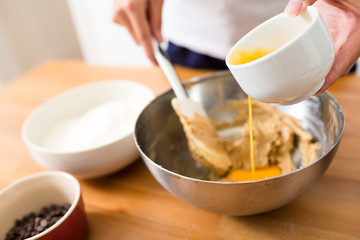 Woman mixing the paste with adding egg