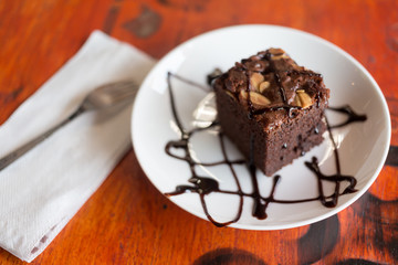 Brownies with chocolate sauce topping on white plate