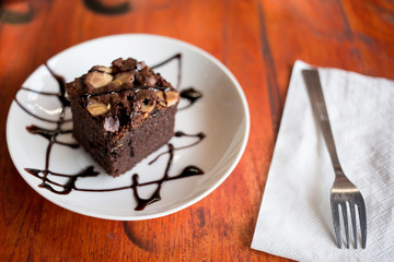 Brownies with chocolate sauce topping on white plate