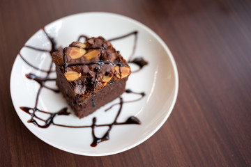 Brownies with chocolate sauce topping on white plate