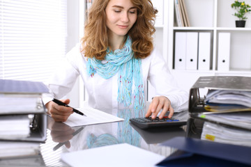 Bookkeeper or financial inspector  making report, calculating or checking balance. Internal Revenue Service checking financial document. Audit concept.