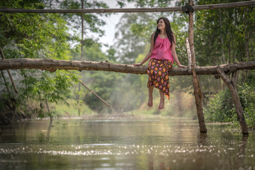 girl in asia traditional dress sitting on waterside.