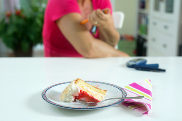 Female diabetic patient injecting herself with shot of insulin before haveing a piece of cake for desert.