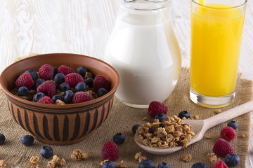 Muesli with fresh berries, orange juice and milk.
